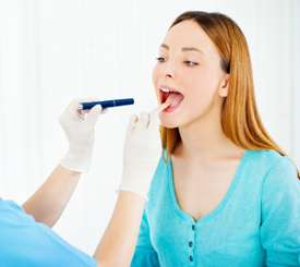 Doctor checking the throat of a female patient